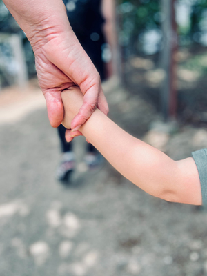 Die Hand eines Kindes wird von einer erwachsenen Hand gehalten.