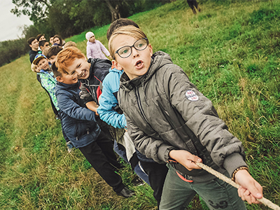 Kinder ziehen gemeinsam an seinem Seil